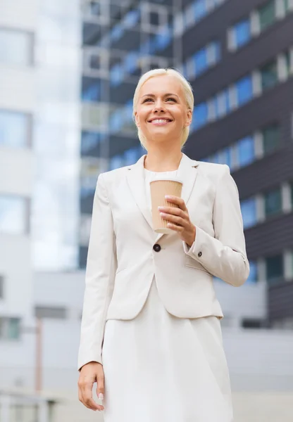 Femme d'affaires souriante avec tasse en papier à l'extérieur — Photo