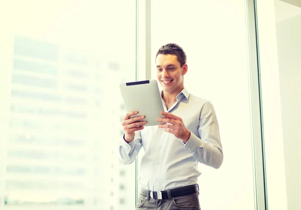 Homme d'affaires souriant avec tablette PC au bureau — Photo