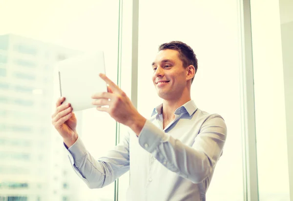 Smiling businessman with tablet pc in office — Stock Photo, Image