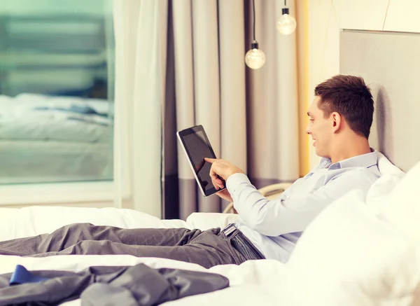 Heureuse femme d'affaires avec tablette PC dans la chambre d'hôtel — Photo