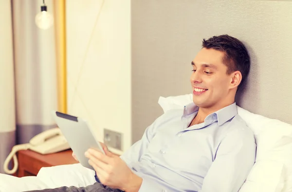 Happy businesswoman with tablet pc in hotel room — Stock Photo, Image