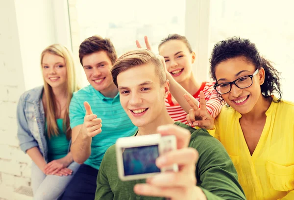 Fünf lächelnde Studenten beim Fotografieren mit der Kamera — Stockfoto