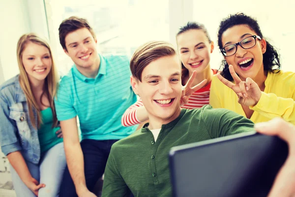 Smiling students making selfie with tablet pc — Stock Photo, Image