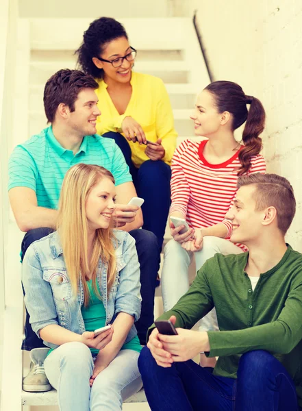 Lachende studenten met smartphone discussie — Stockfoto