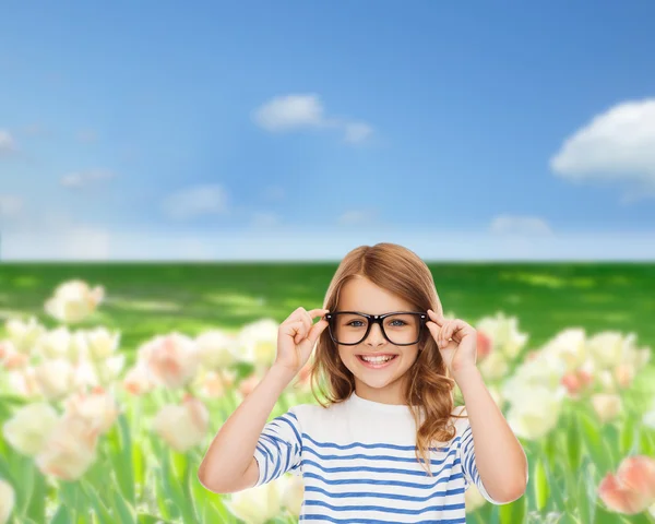 Sorrindo bonito menina com óculos pretos — Fotografia de Stock