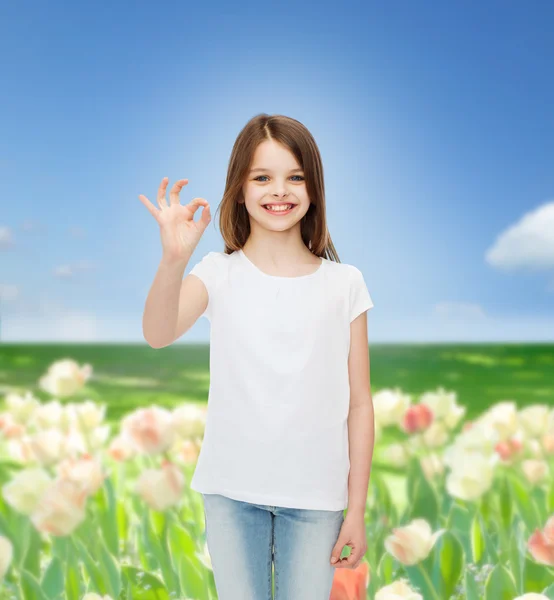 Lächelndes kleines Mädchen in weißem Blanko-T-Shirt — Stockfoto