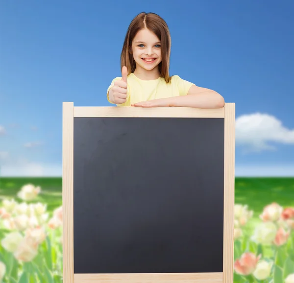 Gelukkig meisje met lege schoolbord — Stockfoto