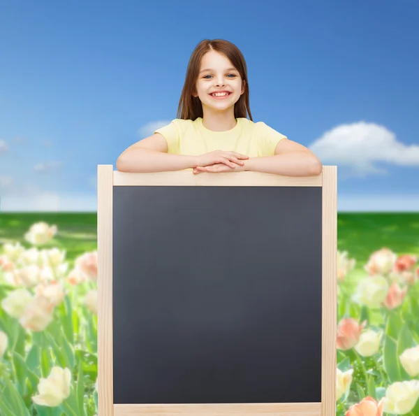 Ευτυχισμένη κοριτσάκι με κενό μαυροπίνακα — Φωτογραφία Αρχείου