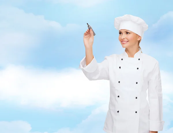 Usmívající se žena šéfkuchař psát něco o letecké — Stock fotografie