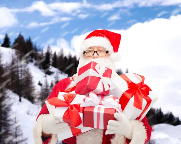 Man in costume of santa claus with gift boxes — Stock Photo, Image