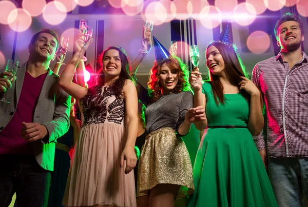 Smiling friends with glasses of champagne in club — Stock Photo, Image