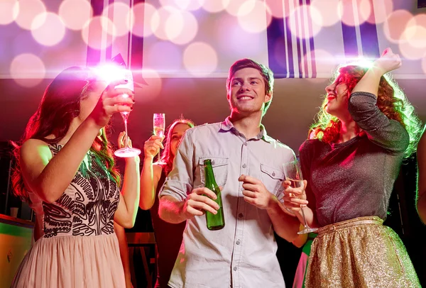 Lächelnde Freunde mit Weingläsern und Bier im Club — Stockfoto