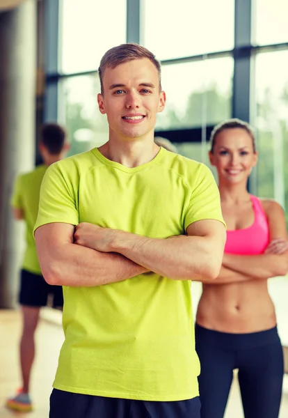 Glimlachende man en vrouw in de sportschool — Stockfoto