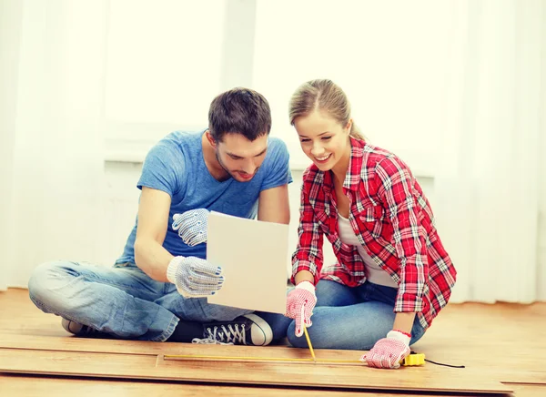 Smiling couple measuring wood flooring — Stock Photo, Image