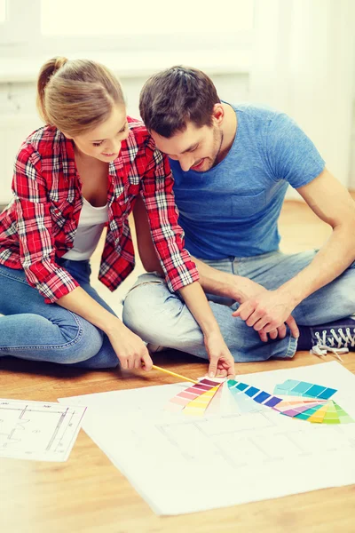 Pareja sonriente mirando muestras de color en casa —  Fotos de Stock