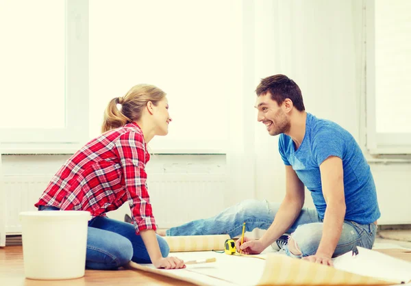 Pareja sonriente midiendo fondo de pantalla — Foto de Stock