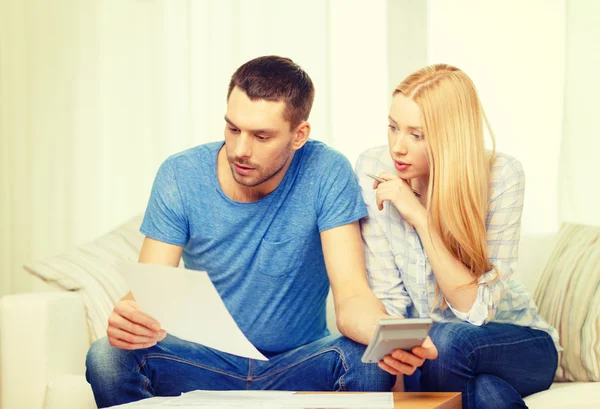 Druk koppel met papieren en rekenmachine thuis — Stockfoto