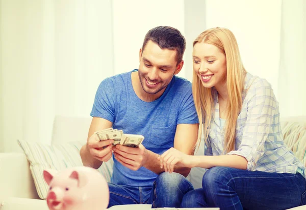 Sorridente coppia contando i soldi a casa — Foto Stock