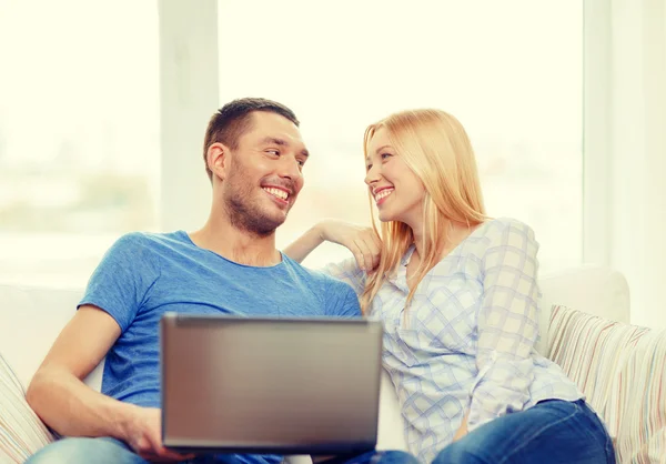 Sorrindo casal feliz com laptop em casa — Fotografia de Stock
