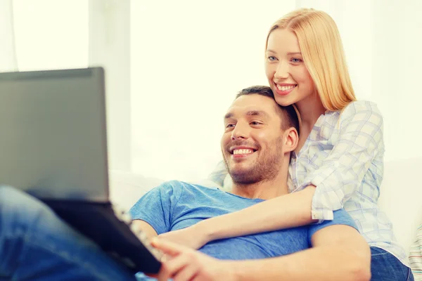 Sorridente coppia felice con computer portatile a casa — Foto Stock