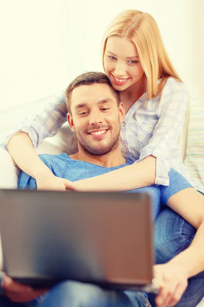Χαμογελαστό ευτυχισμένο ζευγάρι με φορητό υπολογιστή στο σπίτι — Φωτογραφία Αρχείου