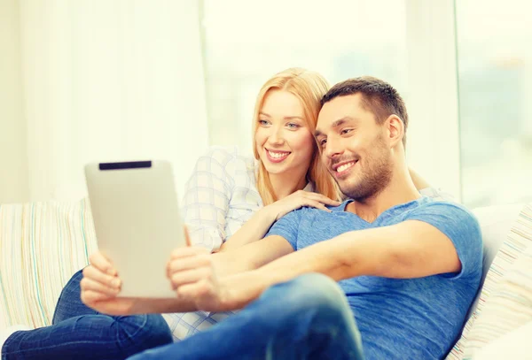 Sorrindo casal feliz com tablet pc em casa — Fotografia de Stock