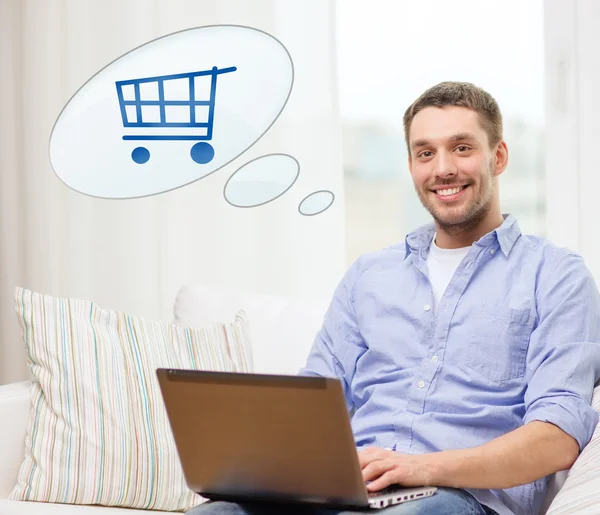 Lächelnder Mann mit Laptop zu Hause online einkaufen — Stockfoto