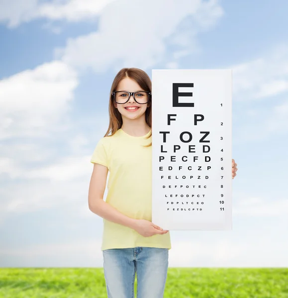 Niña en gafas graduadas con gráfico de comprobación ocular — Foto de Stock