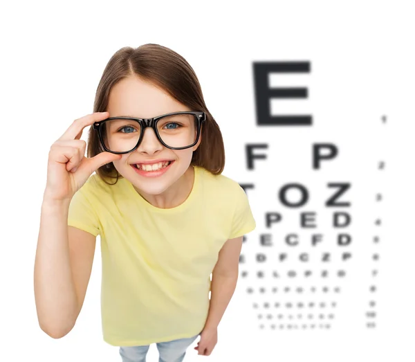 Lächelndes kleines Mädchen in Brille mit Augendiagramm — Stockfoto