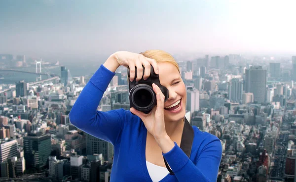 Улыбающаяся женщина фотографируется с цифровой камерой — стоковое фото