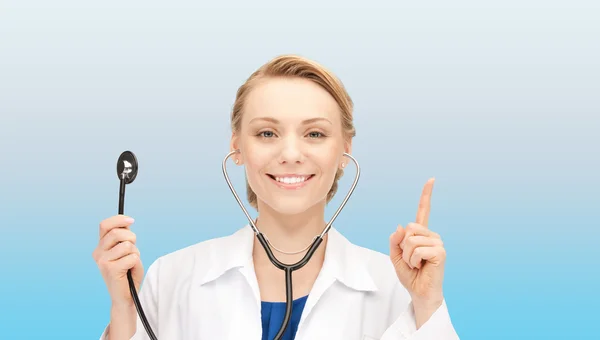 Sourire jeune femme médecin sur fond bleu — Photo