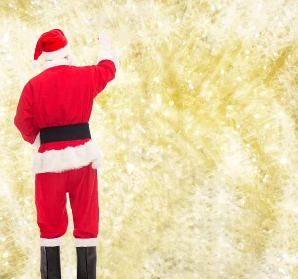 Человек в костюме Санта-Клауса пишет что-то — стоковое фото