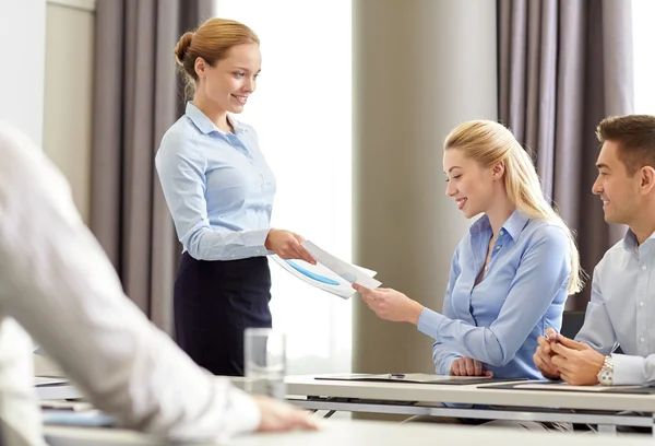 Vrouw geven papieren naar groep zakenlieden — Stockfoto