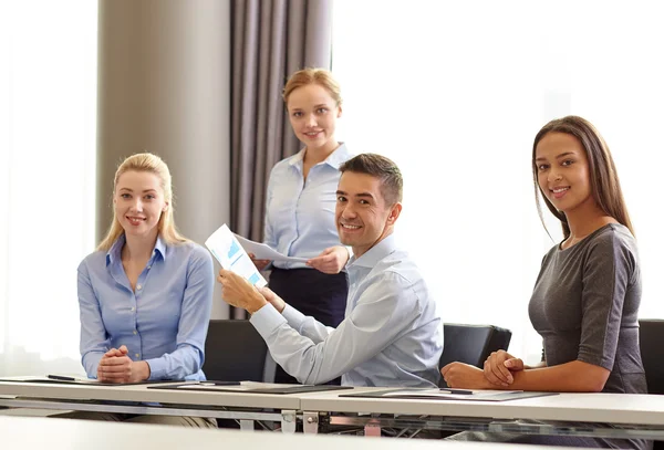 Des gens d'affaires souriants avec des papiers au bureau — Photo