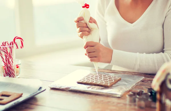 Primer plano de la mujer haciendo casas de pan de jengibre — Foto de Stock