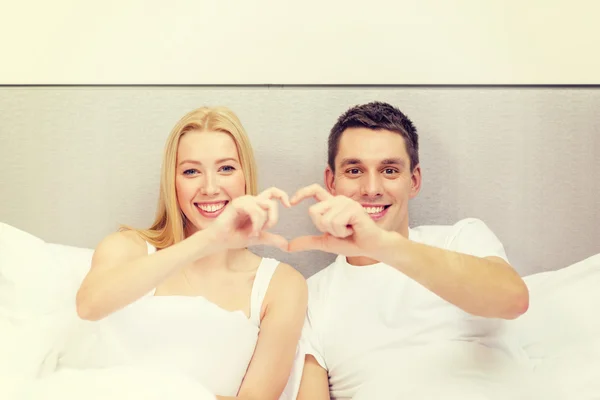 Smiling couple showing heart with hands — Stok fotoğraf