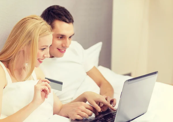 ラップトップ コンピューターとクレジット カードをベッドの中でカップル — ストック写真
