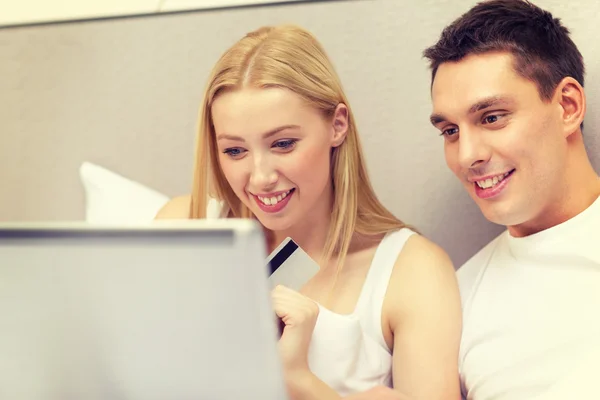 Couple in bed with laptop computer and credit card — Stock Photo, Image