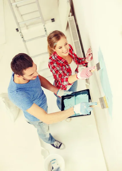 Smiling couple painting wall at home — Stock Photo, Image