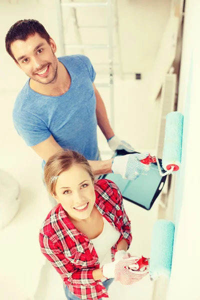 Sorrindo parede casal pintura em casa — Fotografia de Stock