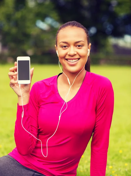Femme afro-américaine souriante avec smartphone — Photo