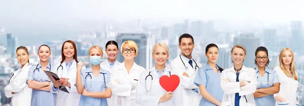 Médicos y enfermeras sonrientes con el corazón rojo —  Fotos de Stock