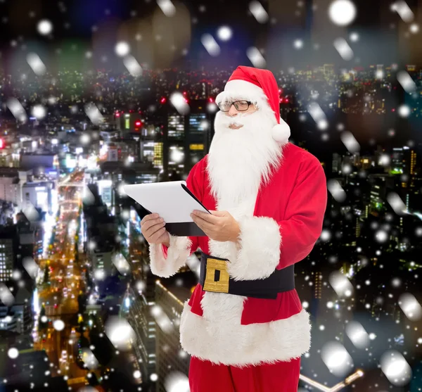 Homem em traje de santa claus com bloco de notas — Fotografia de Stock