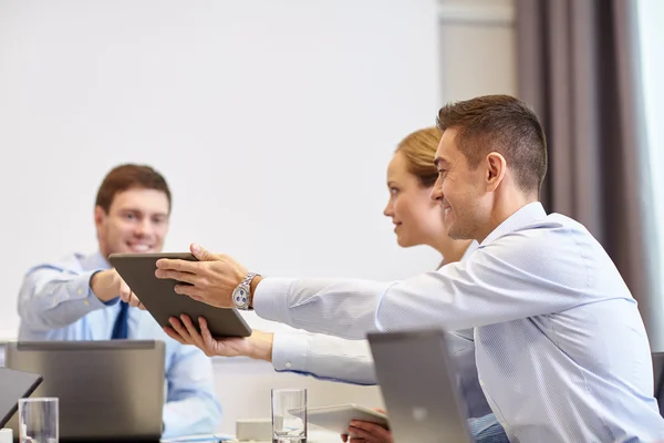 Sonriente gente de negocios con tableta PC en la oficina —  Fotos de Stock
