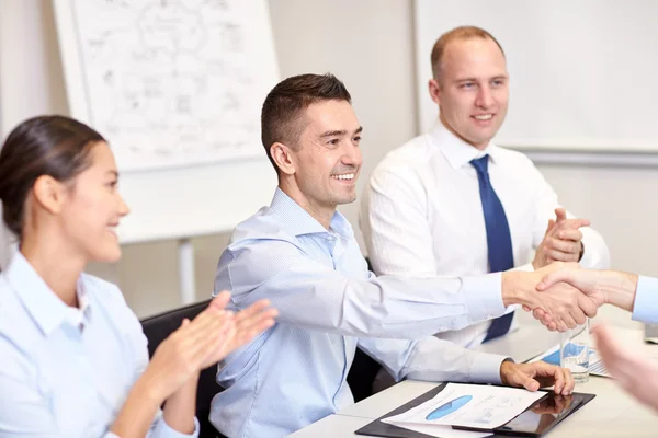 Team di lavoro sorridente che stringe la mano in ufficio — Foto Stock