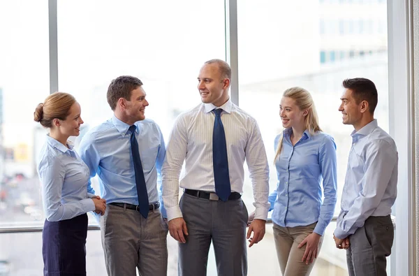 Sorridenti uomini d'affari che parlano in ufficio — Foto Stock