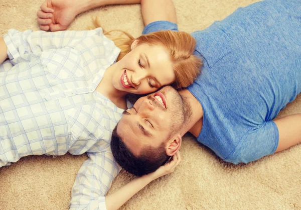 Glimlachend gelukkige paar liggend op vloer thuis — Stockfoto