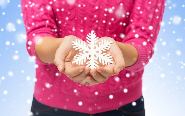 Close up de mulher em suéter segurando floco de neve — Fotografia de Stock