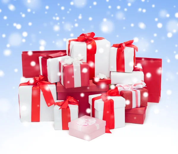 Kar ile mavi arka plan üzerinde Noel hediyeleri — Stok fotoğraf