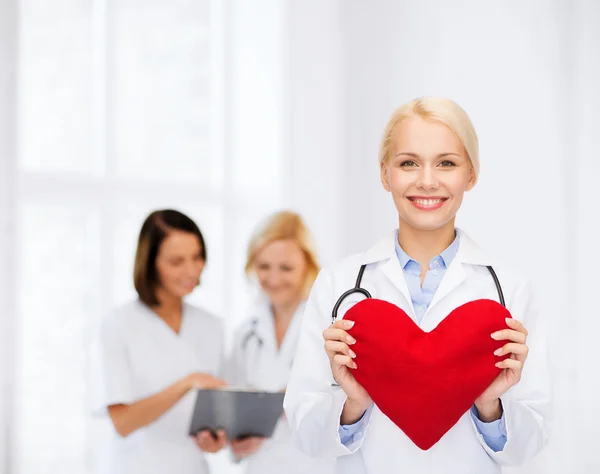 Leende kvinnlig läkare med hjärta och stetoskop — Stockfoto